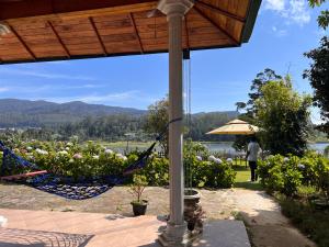 a hammock on a patio with a view of a lake at Lakeside Garden Bungalow 湖畔花园山居 in Nuwara Eliya