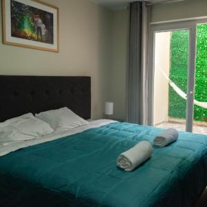 1 dormitorio con cama con sábanas azules y ventana en Hotel Nebai en Ica