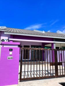 une maison violette avec une clôture devant elle dans l'établissement RAINA MUSLIM FRIENDLY HOMESTAY Perlis, à Arau