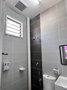 een badkamer met een douche, een toilet en een raam bij RAINA MUSLIM FRIENDLY HOMESTAY Perlis in Arau