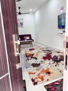een woonkamer met een tapijt op de vloer bij RAINA MUSLIM FRIENDLY HOMESTAY Perlis in Arau