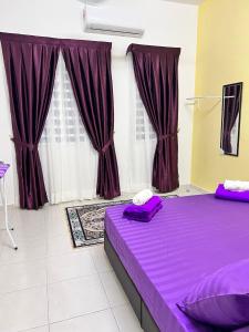 a purple bed in a room with purple curtains at RAINA MUSLIM FRIENDLY HOMESTAY Perlis in Arau