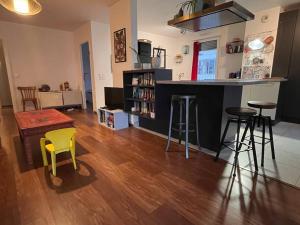 a kitchen and living room with a bar and stools at Spacious & cosy flat in Massy