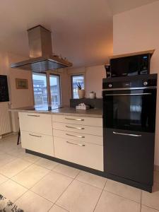 a kitchen with a stove and a microwave at Spacious & cosy flat in Massy