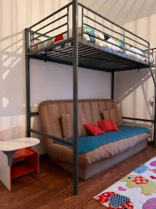 a bunk bed with a couch in a room at Spacious & cosy flat in Massy