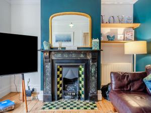 a living room with a fireplace and a mirror at Midships in Dartmouth