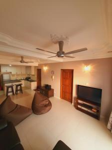 ein Wohnzimmer mit einem Sofa und einem Flachbild-TV in der Unterkunft The Arena's Lavender @ Tanjung Tuan in Port Dickson