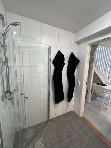 ハルムスタッドにあるStugcentralen Lägenheter & Stugorの黒いシャツ2枚のシャワーが壁に掛けられている