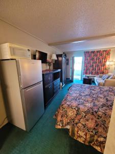 a hotel room with a bed and a refrigerator at Express Inn and Suites in Gastonia