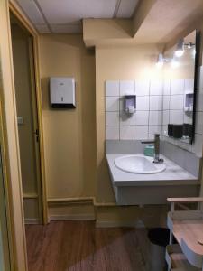 y baño con lavabo y espejo. en Les Halles, en Chaumont