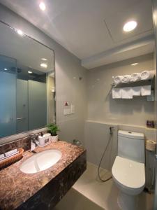 a bathroom with a sink and a toilet and a mirror at BV1 STUDIO KK CITY CENTRE WITH POOL NEAR Imago in Kota Kinabalu