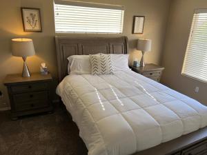 una camera da letto con un grande letto bianco con due comodini di Spacious, comfortable & relaxing home 4 a Las Cruces