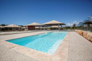 a swimming pool with blue water in front of a building at Crowdy Bay Eco Resort in Harrington