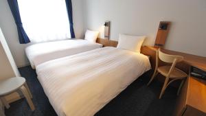 una camera d'albergo con letto, scrivania e sedia di Toyoko Inn Tokyo Haneda Airport No.2 a Tokyo