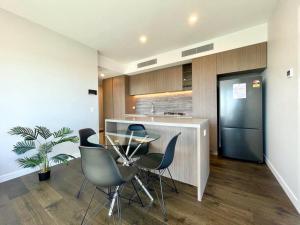 a kitchen with a glass table and chairs and a refrigerator at Broadbeach luxury Casino riverview skyline 2bedroom apt 48F in Gold Coast