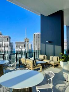 een balkon met tafels en stoelen en uitzicht op de stad bij Broadbeach luxury Casino riverview skyline 2bedroom apt 48F in Gold Coast