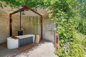Maleny Country Estate في ماليني: حمام مع حوض استحمام بجانب شجرة
