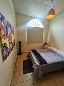1 dormitorio con 1 cama con una pintura en la pared en Boquete destiny, en Boquete