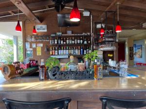un bar con due sedie seduto a un bancone di Red Flamboyan Guesthouse and Restaurant a Rincon