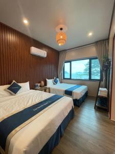 a hotel room with two beds and a window at Cat Ba SOL Beach in Cat Ba