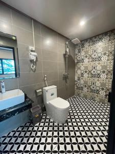 a bathroom with a toilet and a black and white tiled floor at Cat Ba SOL Beach in Cat Ba