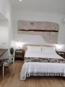 a bedroom with a large bed and a stone wall at Terrazza Campailla in Modica
