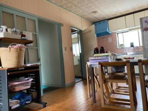 a kitchen with a table and chairs in a room at "Cherry House" is Direct to Narita,Haneda AP, Disney, Asakusa, Skytree Tower, Tokyo in Matsudo