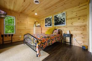 a bedroom with a bed in a wooden cabin at Chic private cabin w/ epic views & amenities! in Cove Creek Cascades