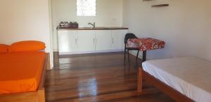 a bedroom with a bed and a table and a chair at Seachange Lodge in Port Vila