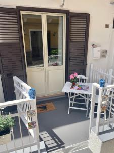 een veranda met 2 stoelen en een tafel met bloemen erop bij Ninni Mondello House in Mondello