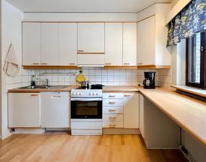 eine Küche mit weißen Schränken und einer Arbeitsplatte in der Unterkunft Tilava huoneisto Keuruun keskustassa in Keuruu