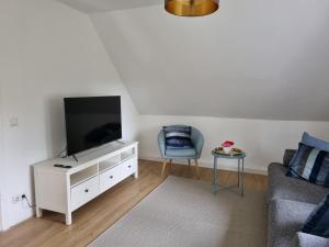 a living room with a flat screen tv and a chair at Horsea 