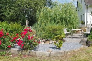 een tuin met een tafel, stoelen en bloemen bij Horsea 