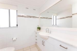 Un baño blanco con lavabo y espejo. en El Sandi Unit 7, en Forster 11 fotos más