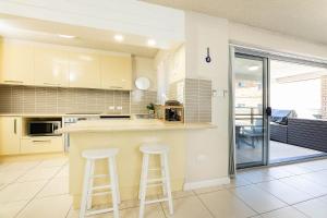 a kitchen with a counter and two stools at El Sandi Unit 7 in Forster