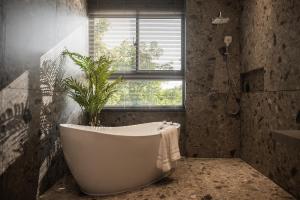 a bathroom with a tub and a plant in it at WiSmart in Taichung