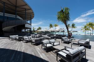 eine Terrasse des Resorts mit Liegestühlen und einem Pool in der Unterkunft Madifushi Private Island in Meemu Atoll