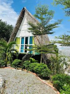 uma casa com telhado de palha e telhado de palha em VulunVili Homestay em Tây Ninh