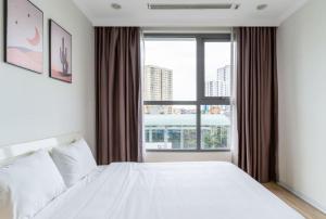 een slaapkamer met een wit bed en een groot raam bij Chi's housse - Vinhomes Time city - 3BR in Hanoi