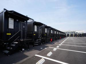 una fila de vagones estacionados en un estacionamiento en HOTEL R9 The Yard Kaizu en Kaizu