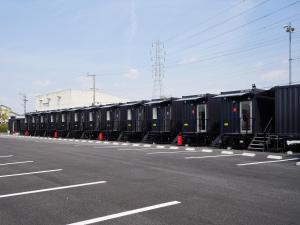 Une rangée de voitures de train noires garées dans un parking dans l'établissement HOTEL R9 The Yard Kaizu, à Kaizu