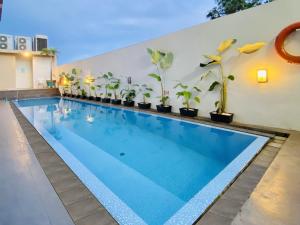 una piscina con macetas en un edificio en KHAS Pekanbaru Hotel, en Pekanbaru