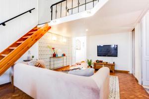 sala de estar con sofá blanco y escaleras en Sweet Inn - Ethnic Eixample, en Barcelona