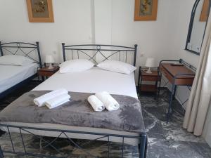 a bedroom with a bed with two towels on it at Meropi Rooms in Kamares