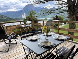 a table and chairs on a deck with a view at Mobil-Home Baie Saint-Michel, Serre-Ponçon in Chorges