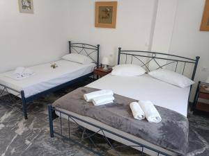two beds in a room with towels on them at Meropi Rooms in Kamares