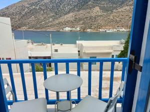 a balcony with chairs and a view of the water at Meropi Rooms in Kamares