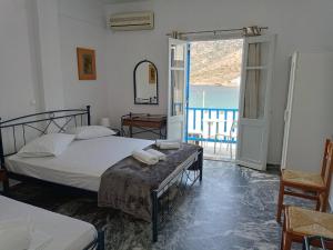 um quarto com uma cama, uma mesa e uma janela em Meropi Rooms em Kamari