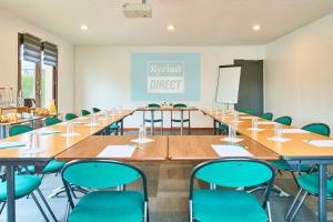 a conference room with tables and chairs and a chalkboard at Kyriad Direct Le Havre Est - Gonfreville in Gonfreville-lʼOrcher