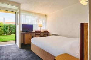 ein Hotelzimmer mit einem Bett und einem TV in der Unterkunft Kyriad Direct Le Havre Est - Gonfreville in Gonfreville-lʼOrcher